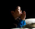 boy praying on bed SCH r