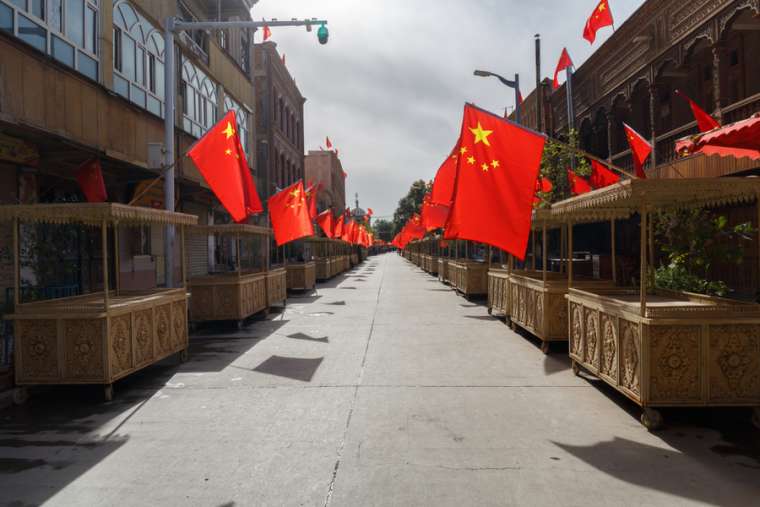 Đường phố với các quầy hàng trong chợ với cờ Trung Quốc trên mọi gian hàng, Tân Cương, Trung Quốc (Ảnh: Chris Redan / Shutterstock)
